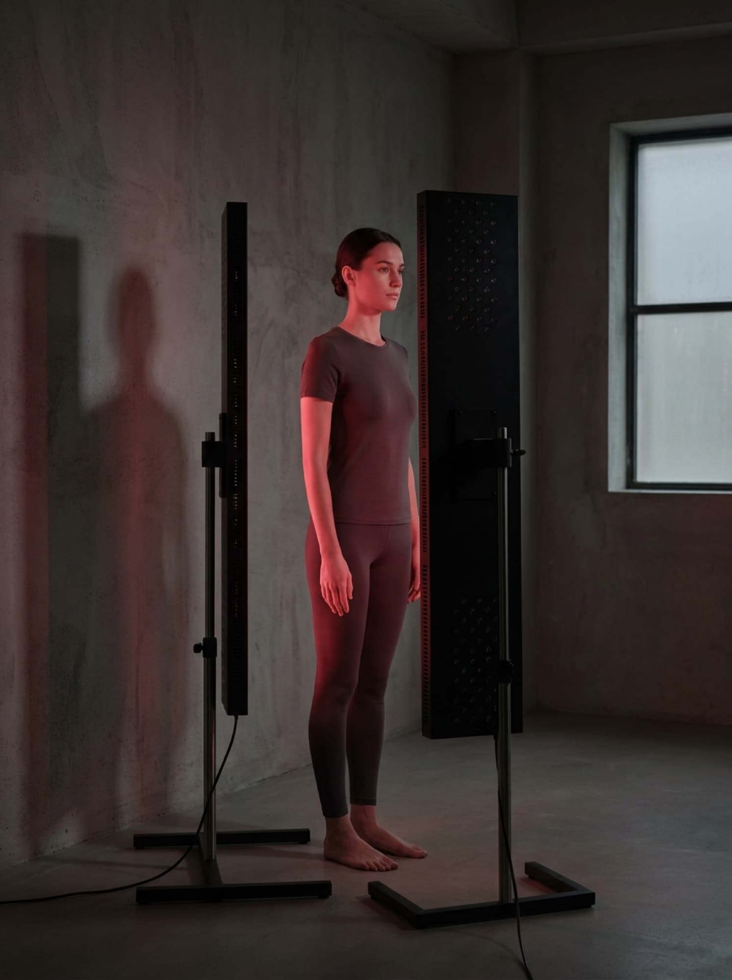 A person standing in front of a full-height red light panel